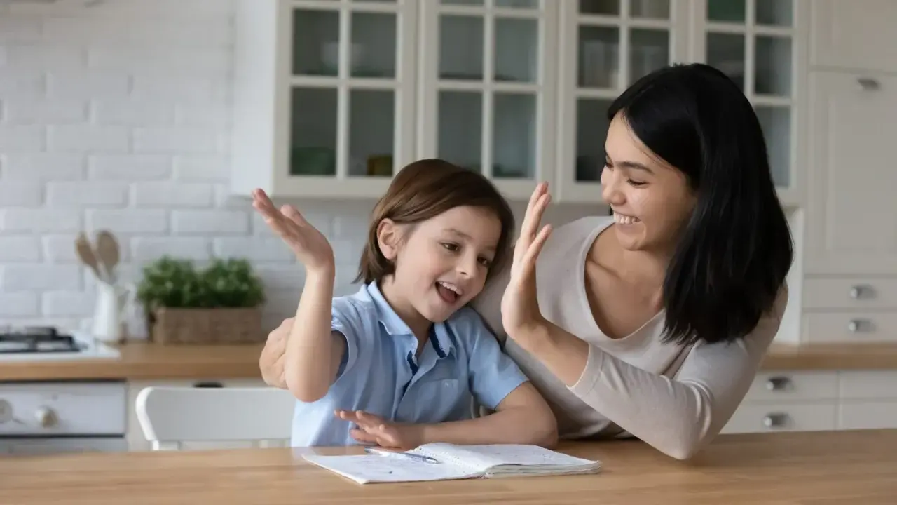 Mutter und Kind geben sich High Five. Das Kind will nicht lernen, aber die Mutter motiviert es.