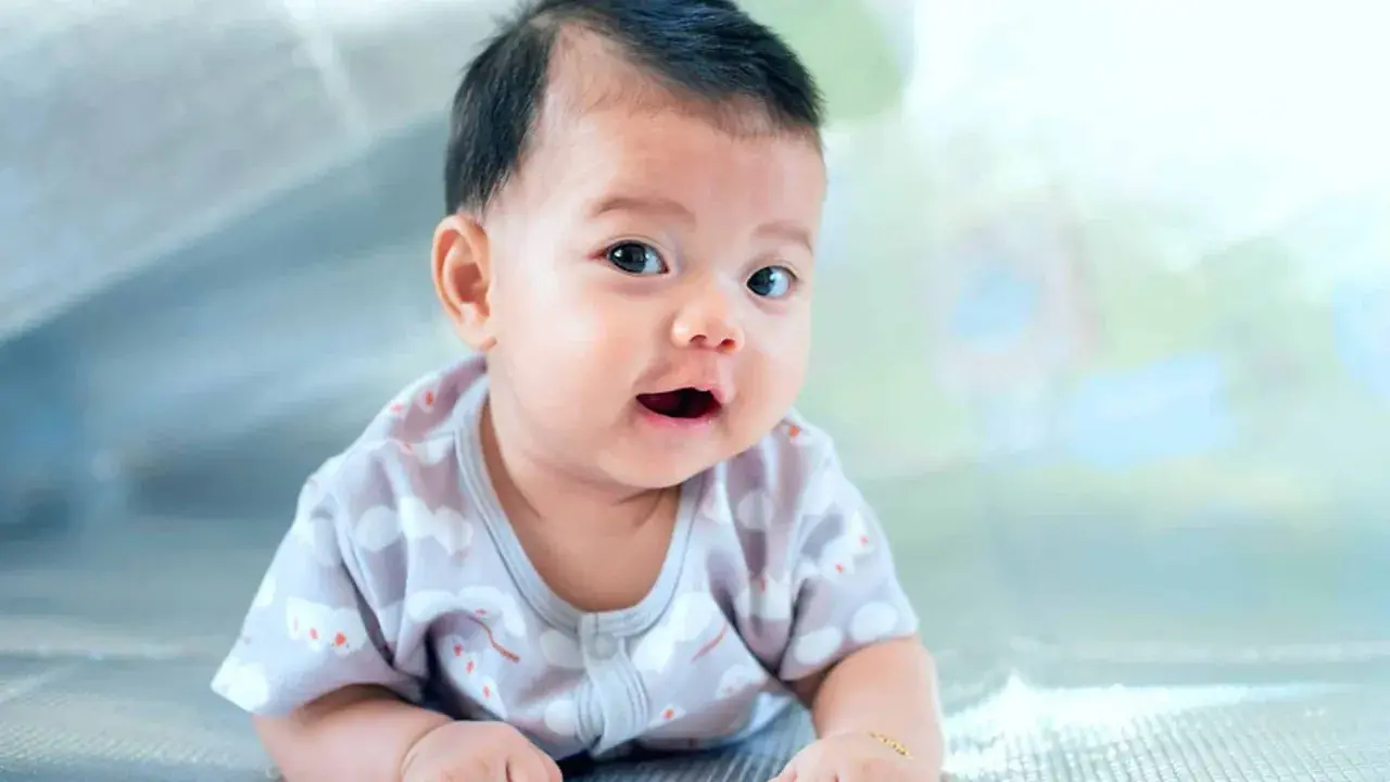 Ein Baby mit dunklem Haar liegt auf dem Bauch. Seine Eltern überlegen, welche vietnamesischen Namen am besten zu ihm passen.