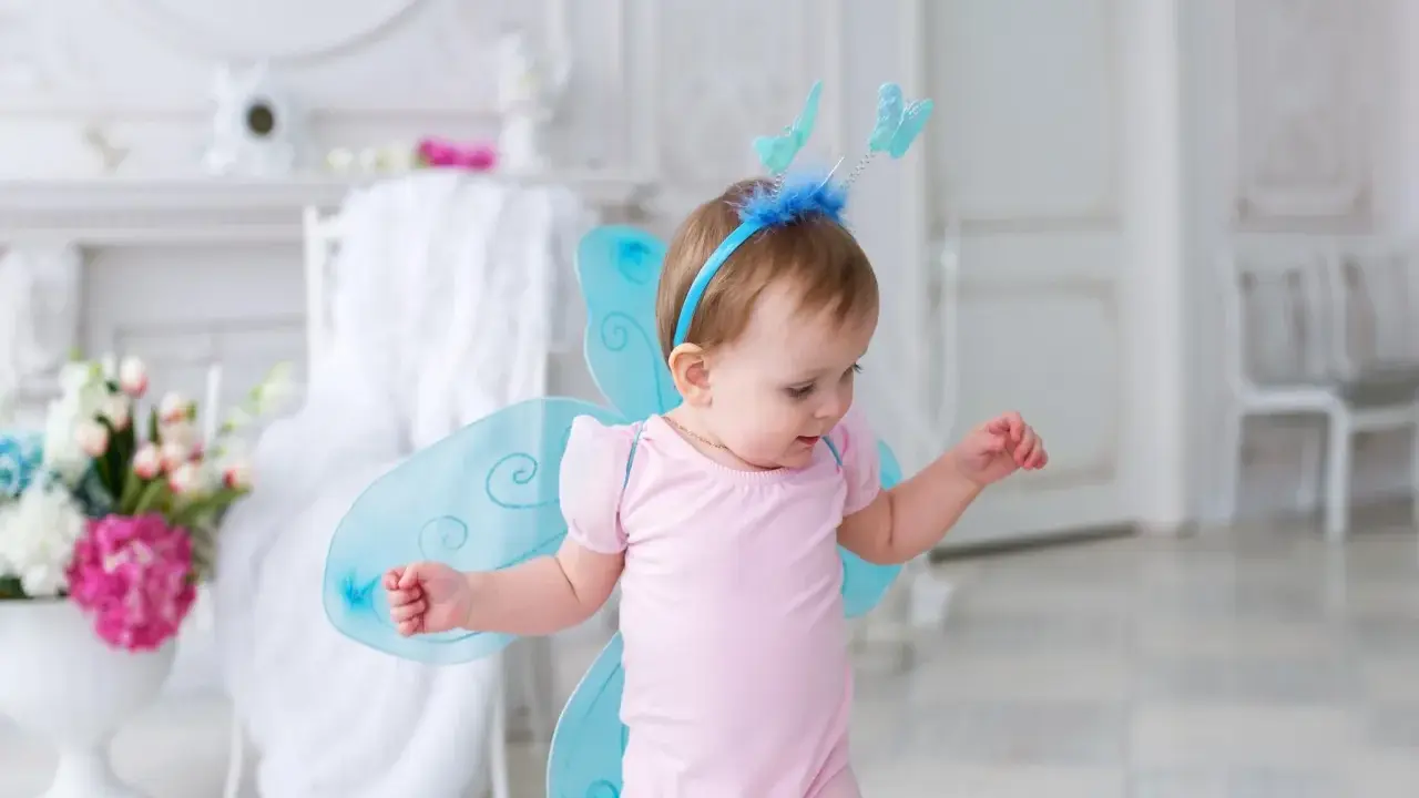 Kleines Mädchen mit Schmetterlingsflügeln und einem Diadem, wie ein kleiner Elfenname weiblich.