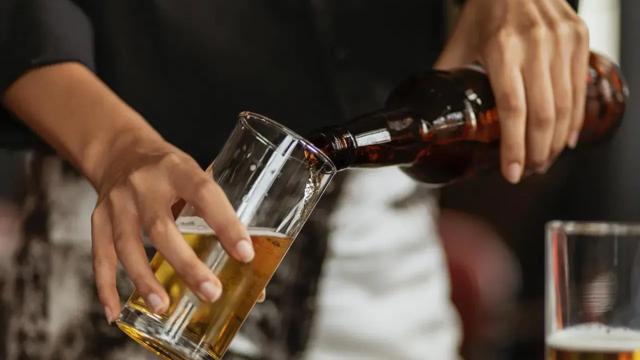 Hände gießen alkoholfreies Bier in ein Glas. Ein Durstlöscher für jeden Anlass.