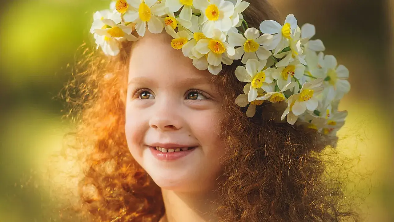 Ein Mädchen mit roten Locken und einem Blumenkranz im Haar, das an keltische Namen weiblich erinnert.