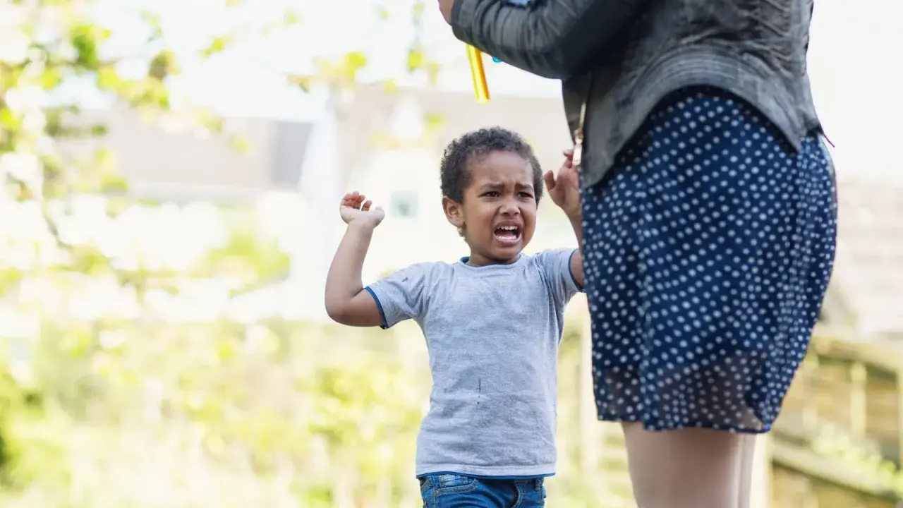 Kind weint, weil es nicht will, dass die Seifenblasen aufhören. Was tun, wenn Kinder schlagen? Geduld und Ablenkung helfen.