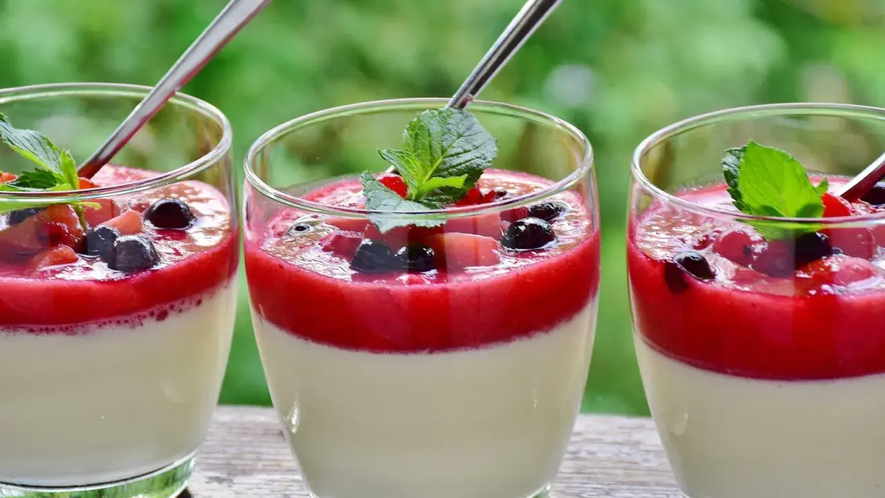 Drei Gläser Panna Cotta mit Beeren und Minze, ein Genuss für jede werdende Mutter.