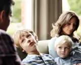 Ein Junge spricht mit seinem Vater, während seine Mutter und sein jüngerer Bruder zuhören. Eine Szene, die zeigt, wie Kinder mit der Trennung der Eltern umgehen.