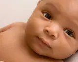 Ein Baby mit dunkler Haut und großen Augen, dessen Eltern sich vielleicht syrische Namen für ihr Kind überlegen.