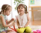 Zwei Mädchen spielen Arzt. Das eine Kind, etwa 7 Jahre alt, untersucht das andere mit einem Stethoskop. Ein spielerischer Einblick in die sexuelle Entwicklung eines Kindes.