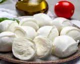 Frische Mozzarellakugeln auf einem Teller, garniert mit Basilikum. Perfekt für eine leichte Mahlzeit während der Schwangerschaft.