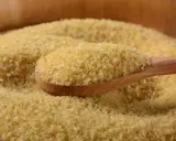 Eine Holzlöffel voller Bulgur, ein gesundes Getreide, das oft in der Ernährung während der Schwangerschaft empfohlen wird.