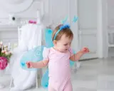 Kleines Mädchen mit Schmetterlingsflügeln und einem Diadem, wie ein kleiner Elfenname weiblich.