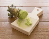 Frisch geriebener Wasabi auf einem Holzbrett. Auch in der Schwangerschaft kann Wasabi in Maßen genossen werden.