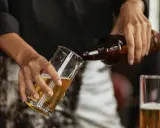 Hände gießen alkoholfreies Bier in ein Glas. Ein Durstlöscher für jeden Anlass.