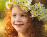 Ein Mädchen mit roten Locken und einem Blumenkranz im Haar, das an keltische Namen weiblich erinnert.