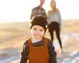 Kleiner Junge mit blauen Augen und schwarzer Mütze, der an die Eltern erinnert, die ihm plattdeutsche Namen geben könnten.