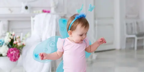 Kleines Mädchen mit Schmetterlingsflügeln und einem Diadem, wie ein kleiner Elfenname weiblich.