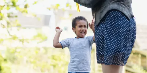 Kind weint, weil es nicht will, dass die Seifenblasen aufhören. Was tun, wenn Kinder schlagen? Geduld und Ablenkung helfen.