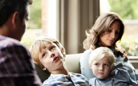 Ein Junge spricht mit seinem Vater, während seine Mutter und sein jüngerer Bruder zuhören. Eine Szene, die zeigt, wie Kinder mit der Trennung der Eltern umgehen.