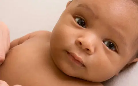 Ein Baby mit dunkler Haut und großen Augen, dessen Eltern sich vielleicht syrische Namen für ihr Kind überlegen.