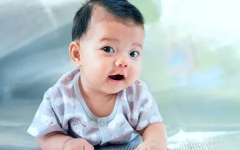 Ein Baby mit dunklem Haar liegt auf dem Bauch. Seine Eltern überlegen, welche vietnamesischen Namen am besten zu ihm passen.