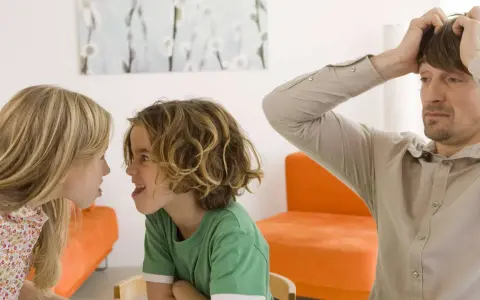 Zwei Kinder streiten sich heftig, während der Vater verzweifelt die Hände über dem Kopf zusammenschlägt. Ein Bild von Geschwisterhass und möglichen Erziehungsfehlern.