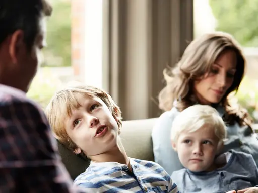 Ein Junge spricht mit seinem Vater, während seine Mutter und sein jüngerer Bruder zuhören. Eine Szene, die zeigt, wie Kinder mit der Trennung der Eltern umgehen.
