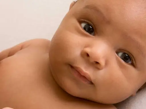 Ein Baby mit dunkler Haut und großen Augen, dessen Eltern sich vielleicht syrische Namen für ihr Kind überlegen.
