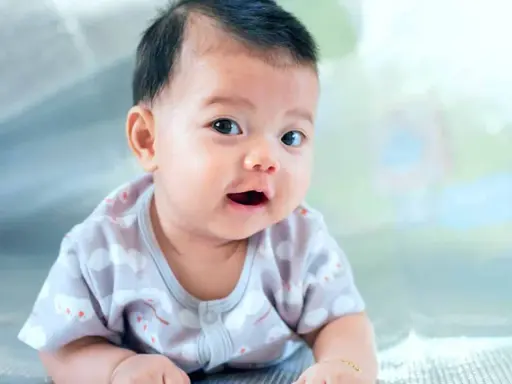 Ein Baby mit dunklem Haar liegt auf dem Bauch. Seine Eltern überlegen, welche vietnamesischen Namen am besten zu ihm passen.