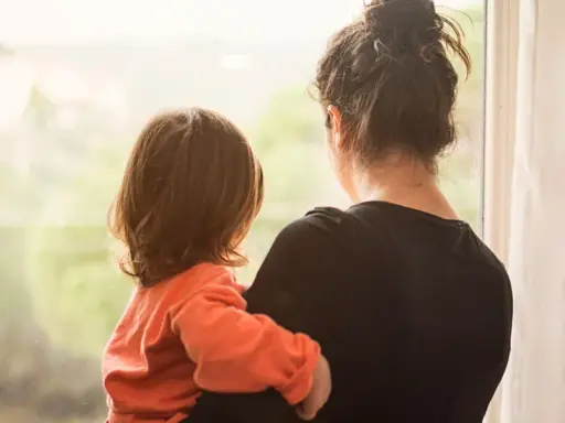 Ein Kind kuschelt sich an seine Mutter, die aus dem Fenster schaut. Die Szene erweckt Gefühle von Geborgenheit, aber auch die leise Angst, die Mutter zu verlieren.