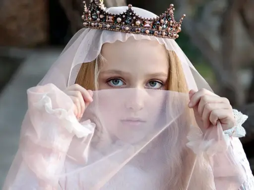 Ein Mädchen mit Krone und Schleier, wie eine Prinzessin aus Herr der Ringe Namen weiblich, blickt geheimnisvoll hervor.