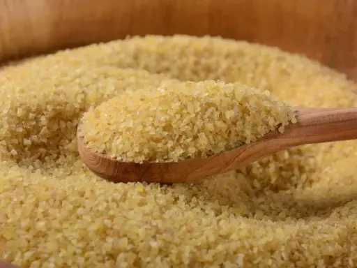 Eine Holzlöffel voller Bulgur, ein gesundes Getreide, das oft in der Ernährung während der Schwangerschaft empfohlen wird.