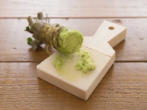 Frisch geriebener Wasabi auf einem Holzbrett. Auch in der Schwangerschaft kann Wasabi in Maßen genossen werden.