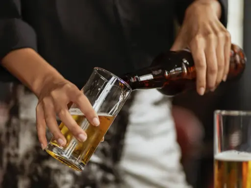 Hände gießen alkoholfreies Bier in ein Glas. Ein Durstlöscher für jeden Anlass.