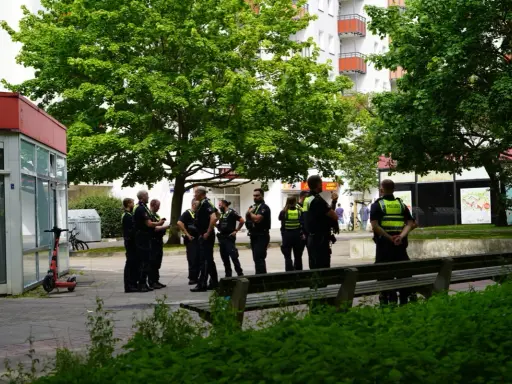 Polizei schreitet ein, wo ein familienstreit eskaliert was tun? Mehrere Beamte stehen vor einem Geschäft und beraten sich.