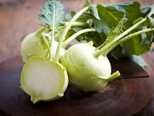 Frische Kohlrabi mit Wassertropfen auf Holz. Ein gesunder Snack, ideal für die Kohlrabi Schwangerschaft.