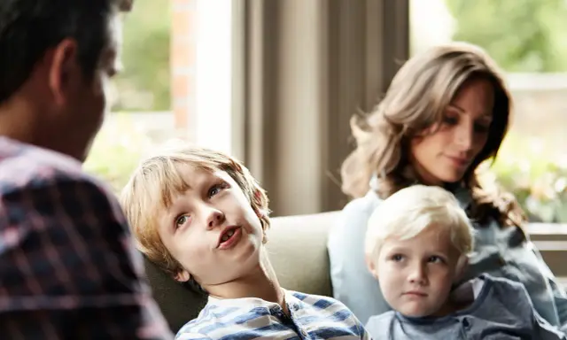 Ein Junge spricht mit seinem Vater, während seine Mutter und sein jüngerer Bruder zuhören. Eine Szene, die zeigt, wie Kinder mit der Trennung der Eltern umgehen.
