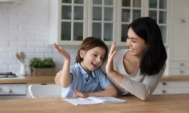 Mutter und Kind geben sich High Five. Das Kind will nicht lernen, aber die Mutter motiviert es.