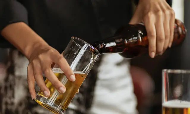 Hände gießen alkoholfreies Bier in ein Glas. Ein Durstlöscher für jeden Anlass.