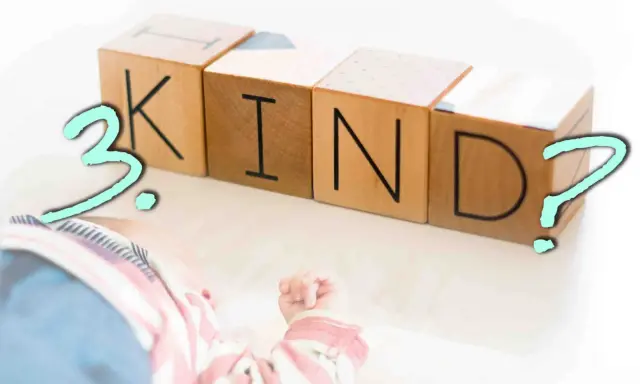 Holzklötze mit den Buchstaben K, I, N, D und einem Fragezeichen. Daneben liegt ein Baby. Ist das dritte Kind eine falsche Entscheidung?