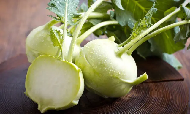 Frische Kohlrabi mit Wassertropfen auf Holz. Ein gesunder Snack, ideal für die Kohlrabi Schwangerschaft.