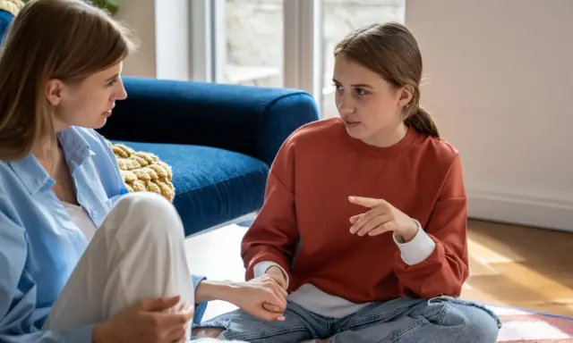 Mutter und Tochter sitzen auf dem Boden. Die Tochter, die mich erwachsene Tochter behandelt mich respektlos, gestikuliert lebhaft.