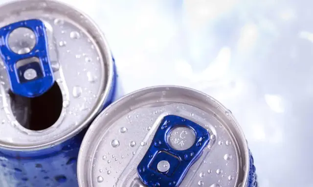 Zwei eisgekühlte Dosen mit blauem Ringpull. Vorsicht bei der Wahl von Energy Drinks in der Schwangerschaft.