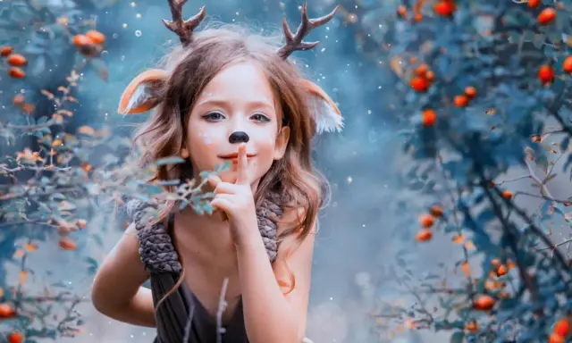 Ein kleines Reh mit Geweih und Ohren, das im Wald steht. Es ist eine magische Phase, in der Kinder Angst vor dem Unbekannten haben, aber auch Neugier zeigen.