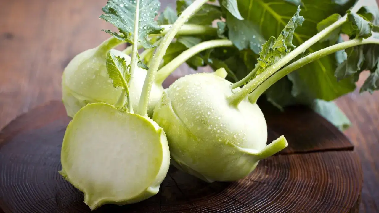 Frischer Kohlrabi mit Wassertropfen auf einem Holzbrett. Ein gesunder Snack für die Schwangerschaft.