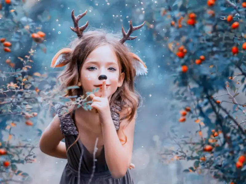 Ein kleines Reh mit Geweih und Ohren, das im Wald steht. Es ist eine magische Phase, in der Kinder Angst vor dem Unbekannten haben, aber auch Neugier zeigen.
